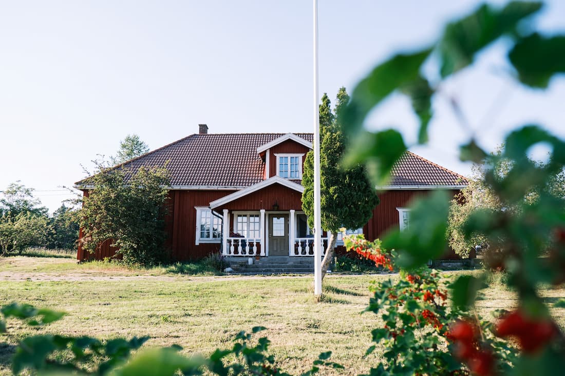 Kaunis näkymä Korpoström Gårdin päärakennukseen pellon keskellä.