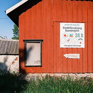 En röd lada med en skylt framför.